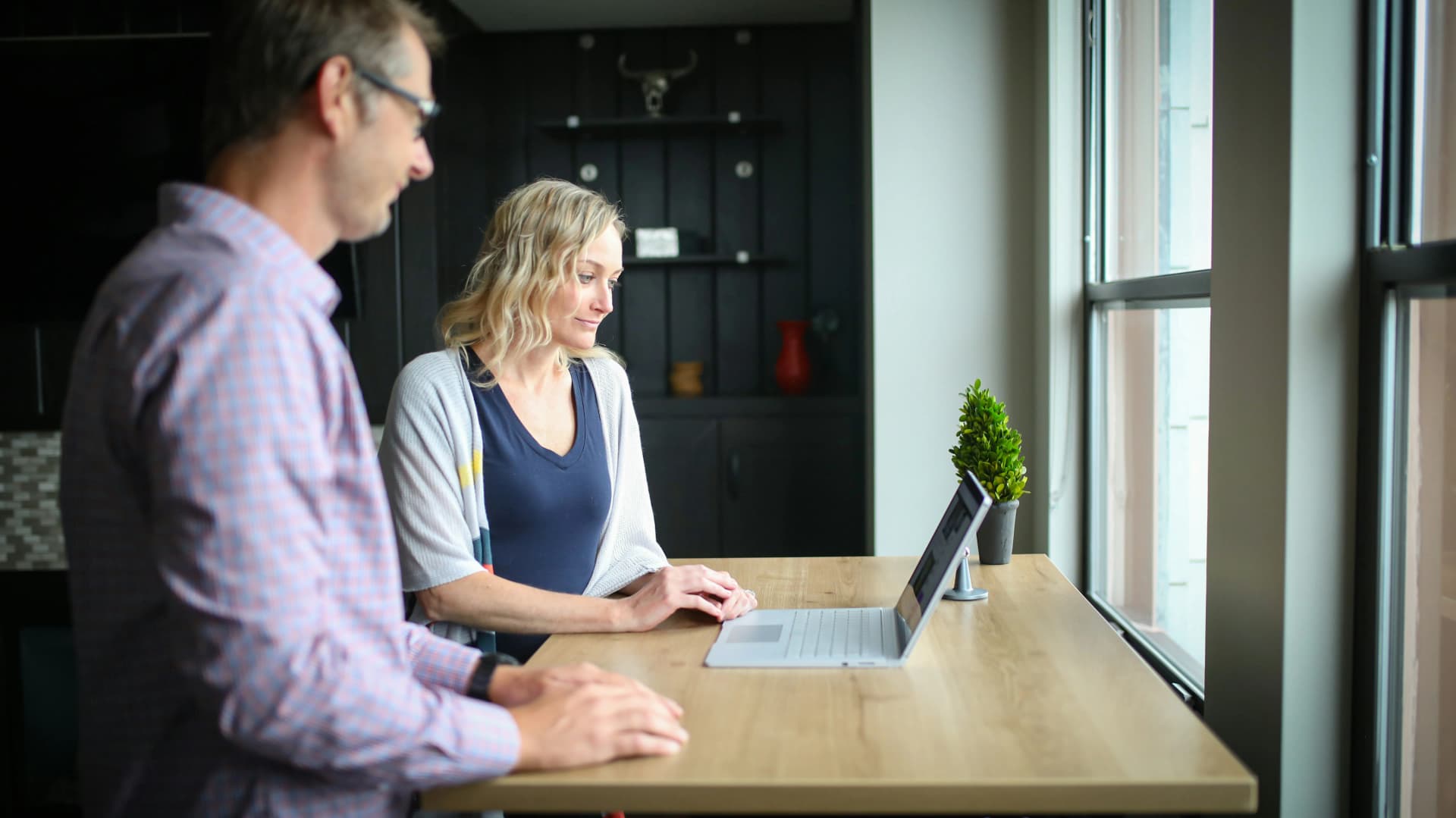 A health coach analyzing a nutrition dashboard with graphs and colorful charts, while a client reviews their meal progress nearby.