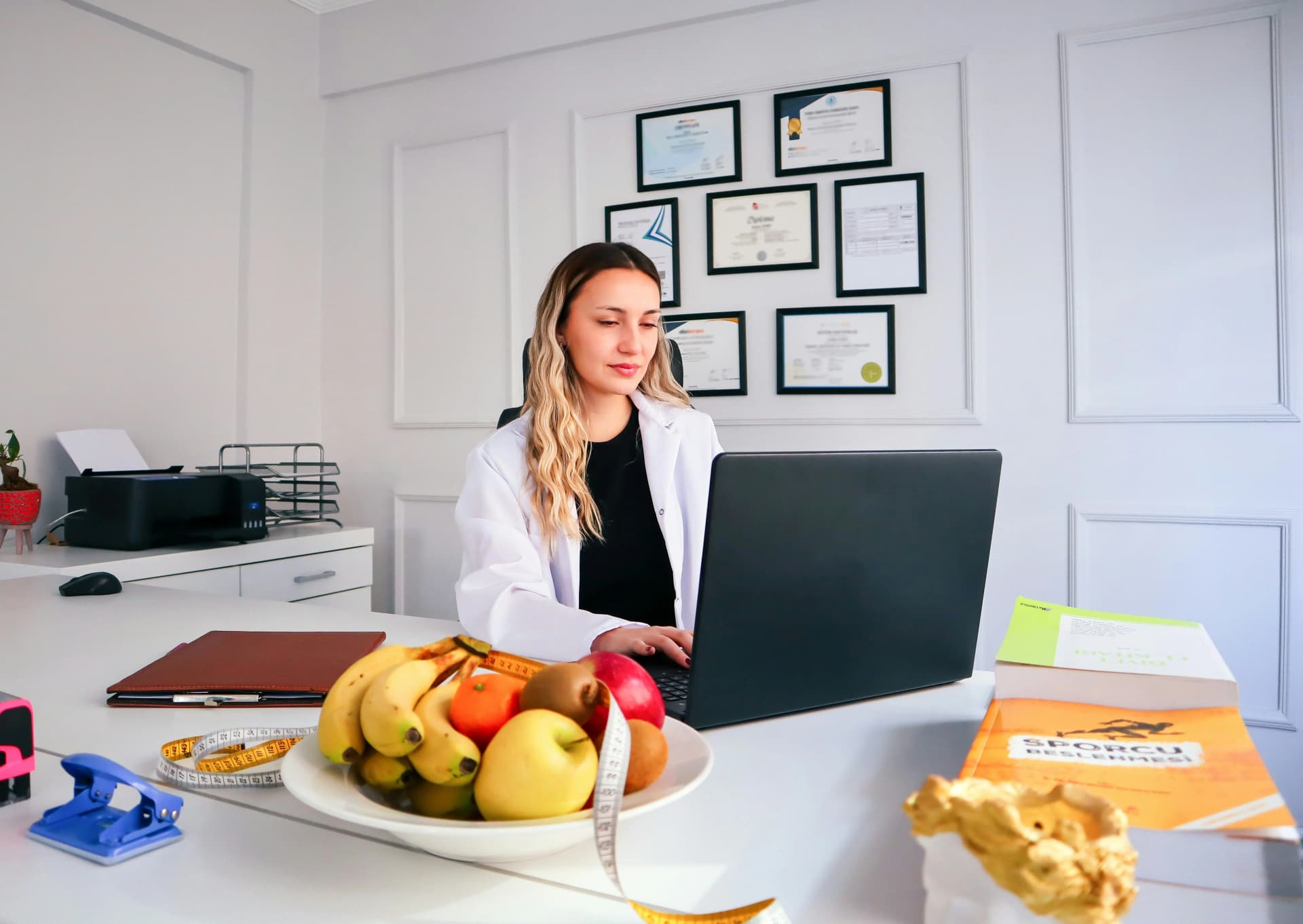 A nutritionist happily collaborating with a client over a meal plan, both smiling and pointing at a colorful weekly meal chart.