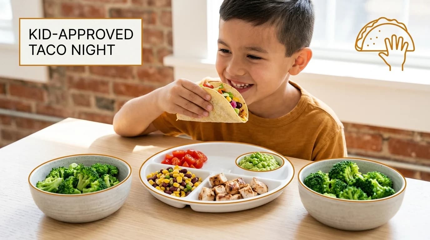 Young boy at a table eating from a divided plate filled with a variety of healthy foods.