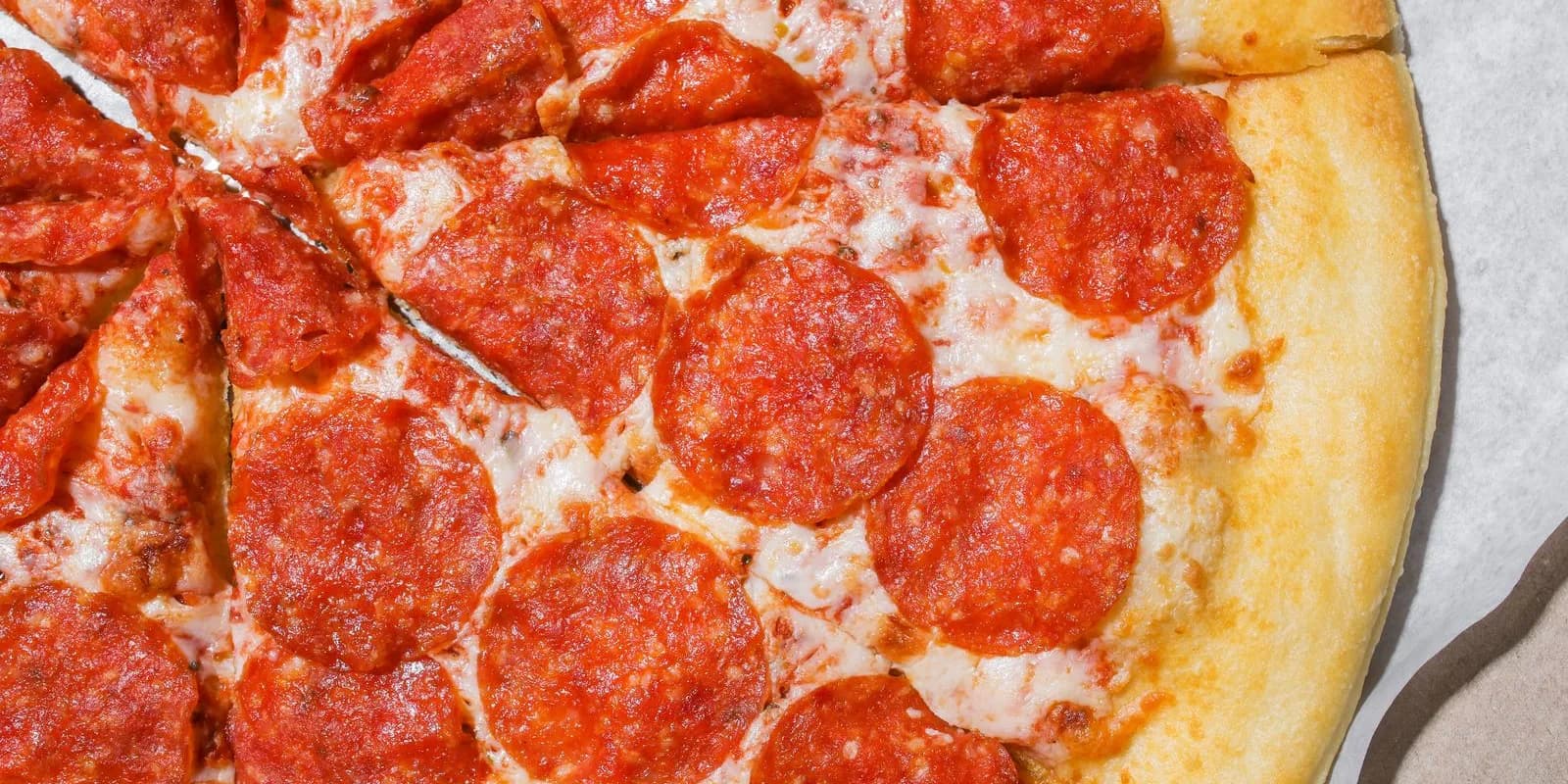 Close-up of pepperoni pizza cut into slices